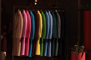 Vibrant coats hanging in a Turin boutique, showcasing a spectrum of colors.