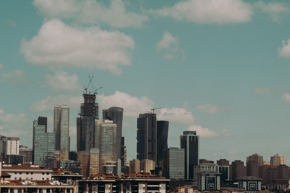Aerial view of a modern city skyline with imposing skyscrapers against a cloudy sky.