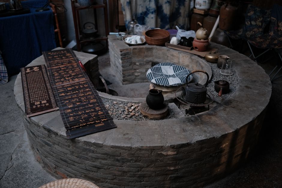 Vintage Chinese brick stove setup with teapots and traditional decor. Perfect for cultural or historical themes.