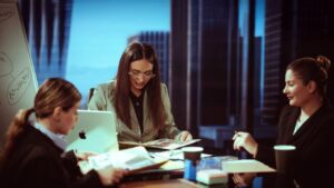 Three businesswomen engaged in a meeting inside a contemporary office.