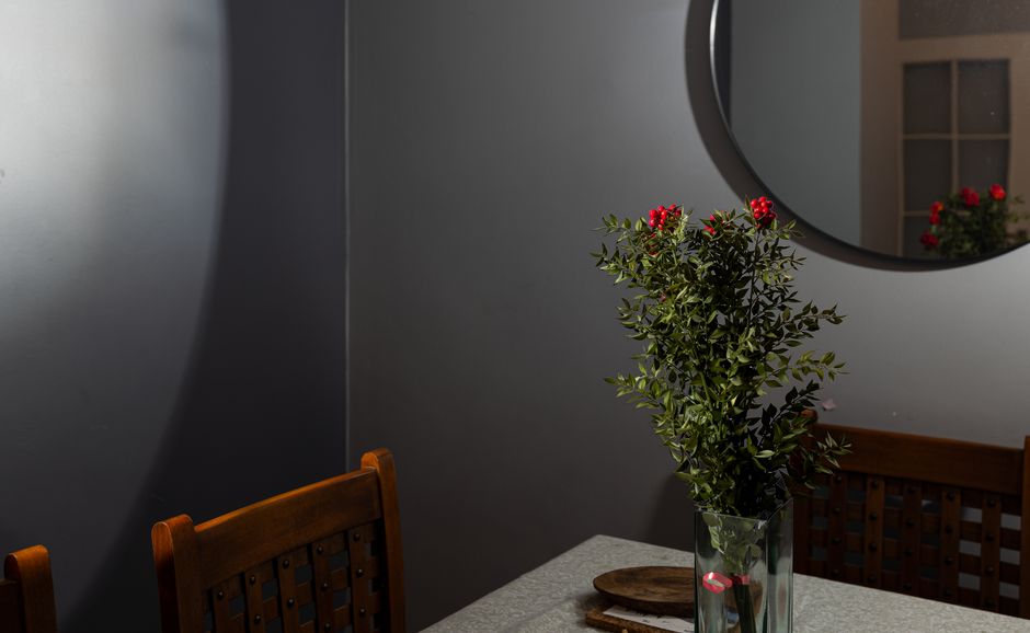 A minimalist indoor setting featuring a kokina flower arrangement in a vase on a dining table.