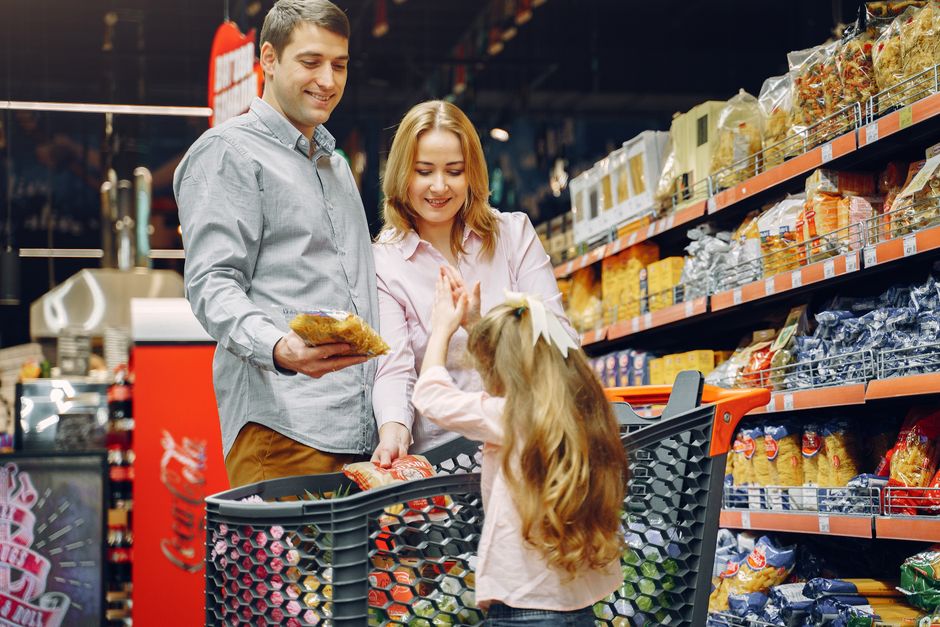 A happy family shopping together in a supermarket aisle, sharing a joyful moment.