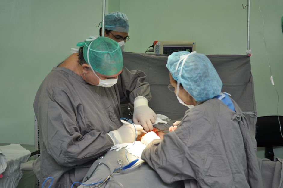 Team of surgeons meticulously performing surgery in an operating room, showcasing medical precision and teamwork.