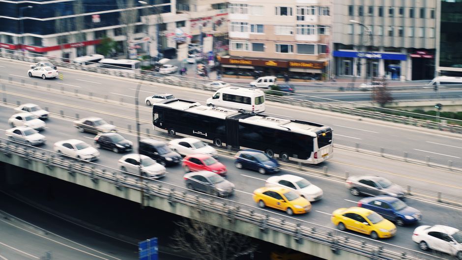 Aerial view of city traffic with cars and a metrobus on a busy roadway.