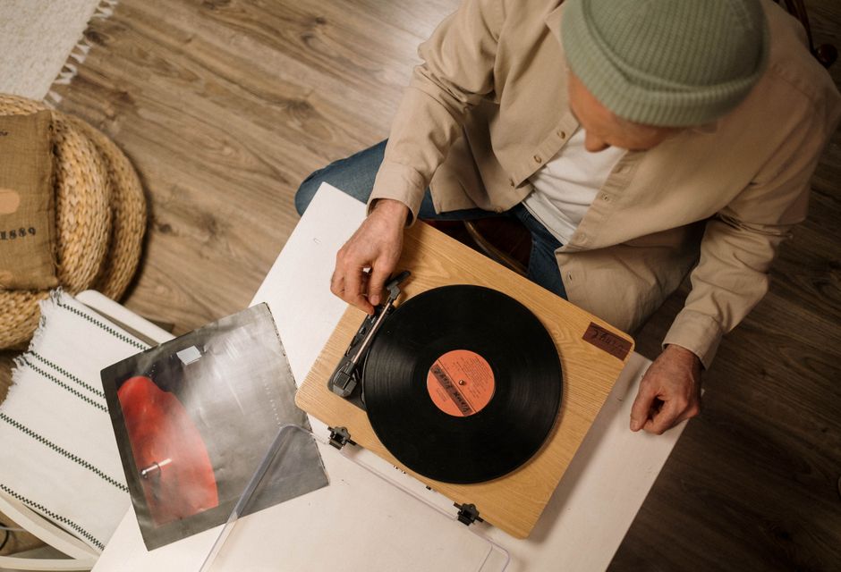 Top-down view of a person playing a vinyl record on a turntable indoors.