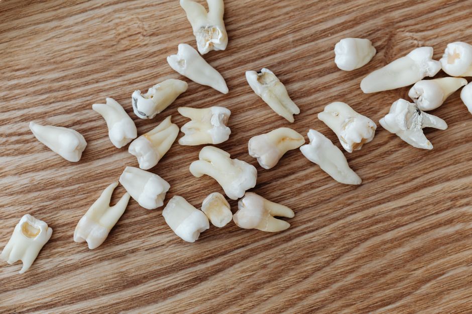 Close-up image of human teeth scattered on a wooden background, ideal for dental topics.
