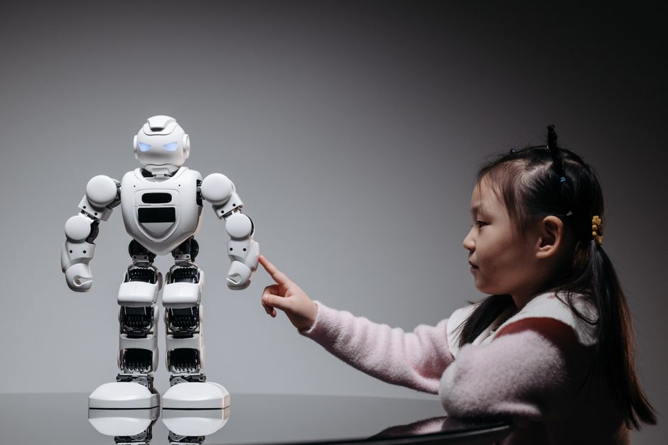 A young girl engaging with a robotic toy, highlighting curiosity and innovation.