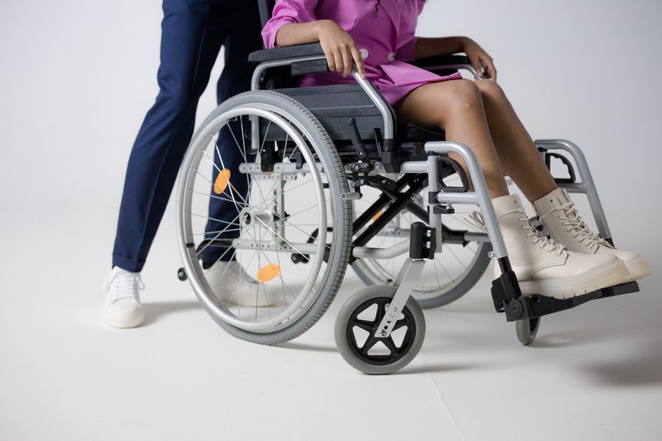 Woman in a pink outfit sitting in a wheelchair, highlighting inclusive fashion.